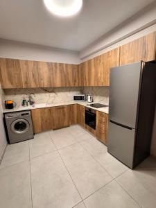 a kitchen with a stainless steel refrigerator and wooden cabinets at Maroulla's Modern & Spacious Family Home near the Beach in Limassol