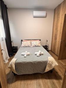 tre peluche sedute su un letto in una camera da letto di Maroulla's Urban Beach Living a Limassol