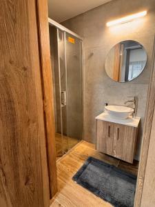 a bathroom with a sink and a shower with a mirror at Maroulla's Modern & Spacious Family Home near the Beach in Limassol +16 photos