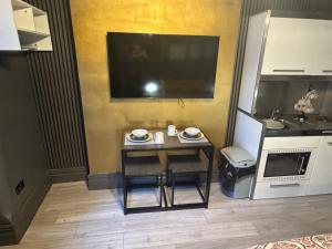 Una mesa pequeña en una cocina con un televisor. en Reads Avenue - Luxury Ground Floor Studio - Next Door to H&A Social Club, en Blackpool