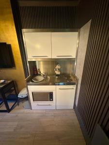 Una pequeña cocina con fregadero y microondas. en Reads Avenue - Luxury Ground Floor Studio - Next Door to H&A Social Club, en Blackpool