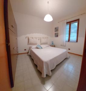 a white bedroom with a large white bed in it at Casa Licia Sorso in Marina di Sorso