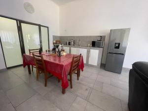 a kitchen with a table with a red table cloth at Wings & dreams in Windhoek