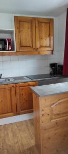 una cucina con mobili in legno e un piano di lavoro di LA NORMA LES BALCONS DE LA Vanoise a La Norma