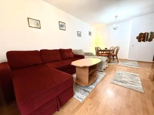 a living room with a red couch and a table at Adela Mountain View Sinaia in Sinaia