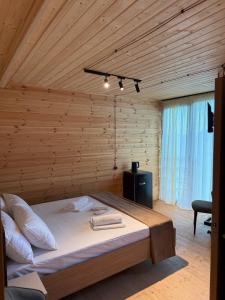Un dormitorio con una cama grande en una habitación de madera. en Kvirike Hills Hotel, en Kobuleti