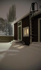 Captains Cabin, Old Town, Kokkola في كوكولا: المنزل مغطى بالثلوج مع نافذة +4 صور
