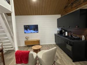 Captains Cabin, Old Town, Kokkola في كوكولا: مطبخ مع طاولة وتلفزيون على الحائط