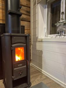 Captains Cabin, Old Town, Kokkola في كوكولا: موقد في غرفة بجوار نافذة