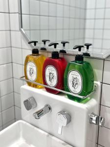 drie flessen wasmiddel bovenop een gootsteen bij full house in Seoul