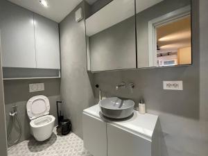 a bathroom with a toilet and a sink at Piazza Downtown Cozy Studio in Tirana