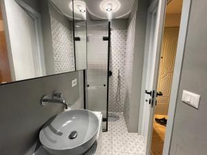 a bathroom with a sink and a shower at Piazza Downtown Cozy Studio in Tirana