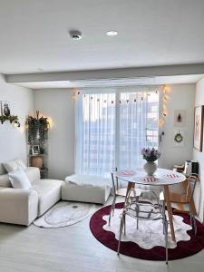 een woonkamer met een tafel en een bank bij full house in Seoul