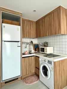 een keuken met een koelkast en een wasmachine bij full house in Seoul