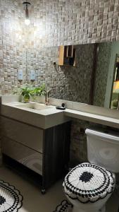 un bagno con lavandino, WC e specchio di Casa Bello encanto a Cachoeira Paulista