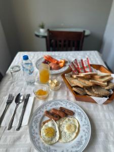 a table with two plates of eggs and sausage and toast at Hotel Halona in Kandy