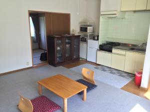 kuchnia ze stołem i krzesłami w pokoju w obiekcie Furano Rental House w mieście Furano