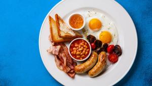 a plate of breakfast food with eggs sausage beans and toast at shabi inn in Ilford