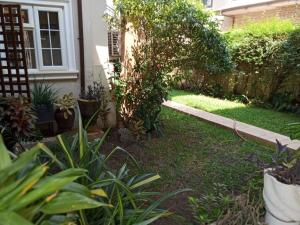 a garden with plants and a house at Etikette Homes in Accra