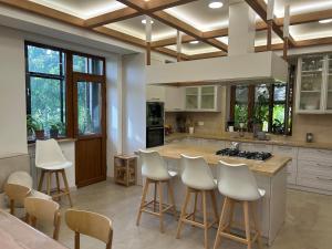 a kitchen with white chairs and a island with a stove at Villa in Nork in Yerevan