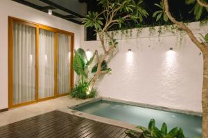 an indoor pool with a tree in a room at 2BR Private Pool Beach Villa Near Sanur & Ubud in Ketewel