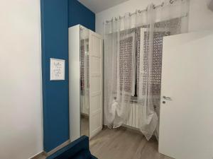 een kamer met een blauwe muur en een deur met gordijnen bij Alloggio Turistico Mare Blu Gaeta in Gaeta +40 foto's