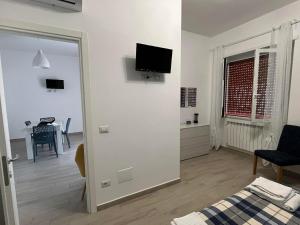 een woonkamer met een bed en een televisie aan de muur bij Alloggio Turistico Mare Blu Gaeta in Gaeta