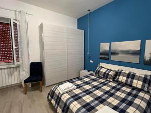 a blue bedroom with a bed and a chair at Alloggio Turistico Mare Blu Gaeta in Gaeta