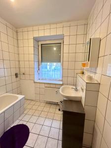 Un baño blanco con bañera, lavabo y bañera. en Geräumige Wohnung Nähe HBF, en Eisenach