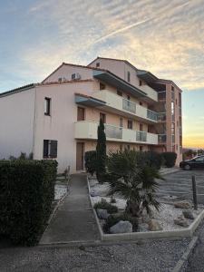 un edificio con un'auto parcheggiata di fronte di Le Barcarelle a Le Barcarès