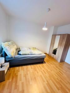 sala de estar con cama y suelo de madera en Geräumige Wohnung Nähe HBF, en Eisenach