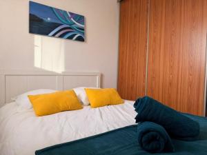 un letto con due cuscini gialli sopra di Le Barcarelle a Le Barcarès