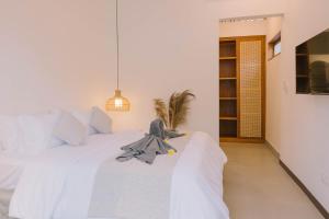 a bedroom with a white bed with a toy on it at Uma Asri Beach Villa in Ketewel