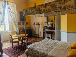 a bedroom with a bed and a desk and a table at Château de Thégra in Balma