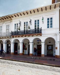 a large white building with arches and a balcony at Casa Firenza Hotel & Suites Boutique in Cuenca
