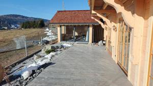 Domki pod łanem في تيلسز: ممشى خشبي يؤدي إلى مبنى مع شرفة