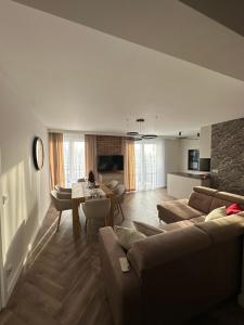 een woonkamer met banken en een tafel en een keuken bij Panorama 79 in Nowy Targ