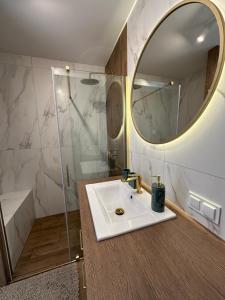 een badkamer met een wastafel en een spiegel bij Panorama 79 in Nowy Targ +3 foto's