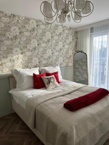 een slaapkamer met een groot bed met rode kussens bij Panorama 79 in Nowy Targ