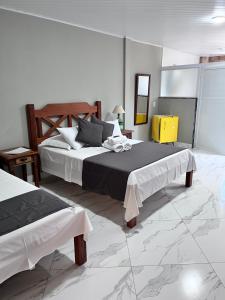 a large bedroom with two beds and a yellow cabinet at Hotel Lumiar in Lumiar