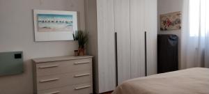 a bedroom with a dresser and a bed with a picture at La casa di Gergy in Borgomanero