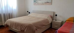 un dormitorio pequeño con una cama y una mesita de noche con una cama sidx sidx sidx en La casa di Gergy, en Borgomanero