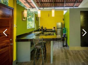 een keuken met gele en groene muren en een aanrecht bij Casas Héctor Rios in Yelapa +16 foto's