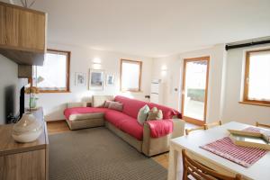 un soggiorno con un divano e un tavolo di CASA BEBA - Cavalese Olimpiadi 2026 Dolomiti Affitti a Cavalese