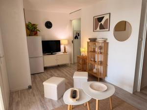 un soggiorno con tavolo e 2 sgabelli di Le Barcarelle a Le Barcarès