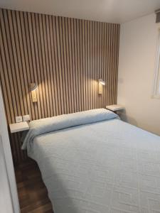 a bedroom with a bed and two lights on the wall at Casa Olas y Arena el Palmar in El Palmar