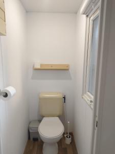 a small bathroom with a toilet and a window at Casa Olas y Arena el Palmar in El Palmar