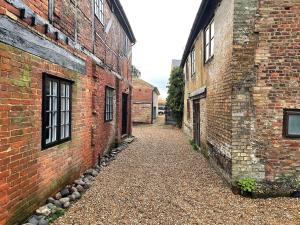 an alley way between two brick buildings at Bishops Keep - A New Unique Town Centre Home in King's Lynn