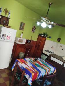 a kitchen with a table and a refrigerator at Depto San Clemente del tuyu centro in San Clemente del Tuyú