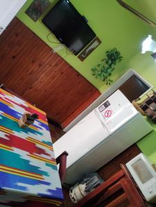 a kitchen with a stove and a tv in a room at Depto San Clemente del tuyu centro in San Clemente del Tuyú